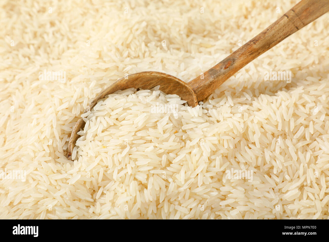 Cucchiaio di bianco a grana lunga riso su sfondo di riso Foto stock - Alamy