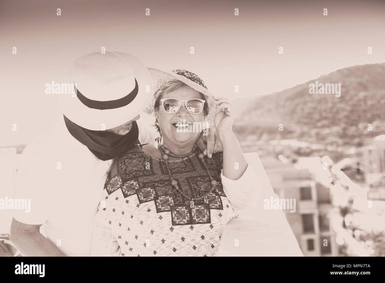 Coppia vintage con cappello sorridono e si coccolano all'aria aperta in terrazza in estate Foto Stock