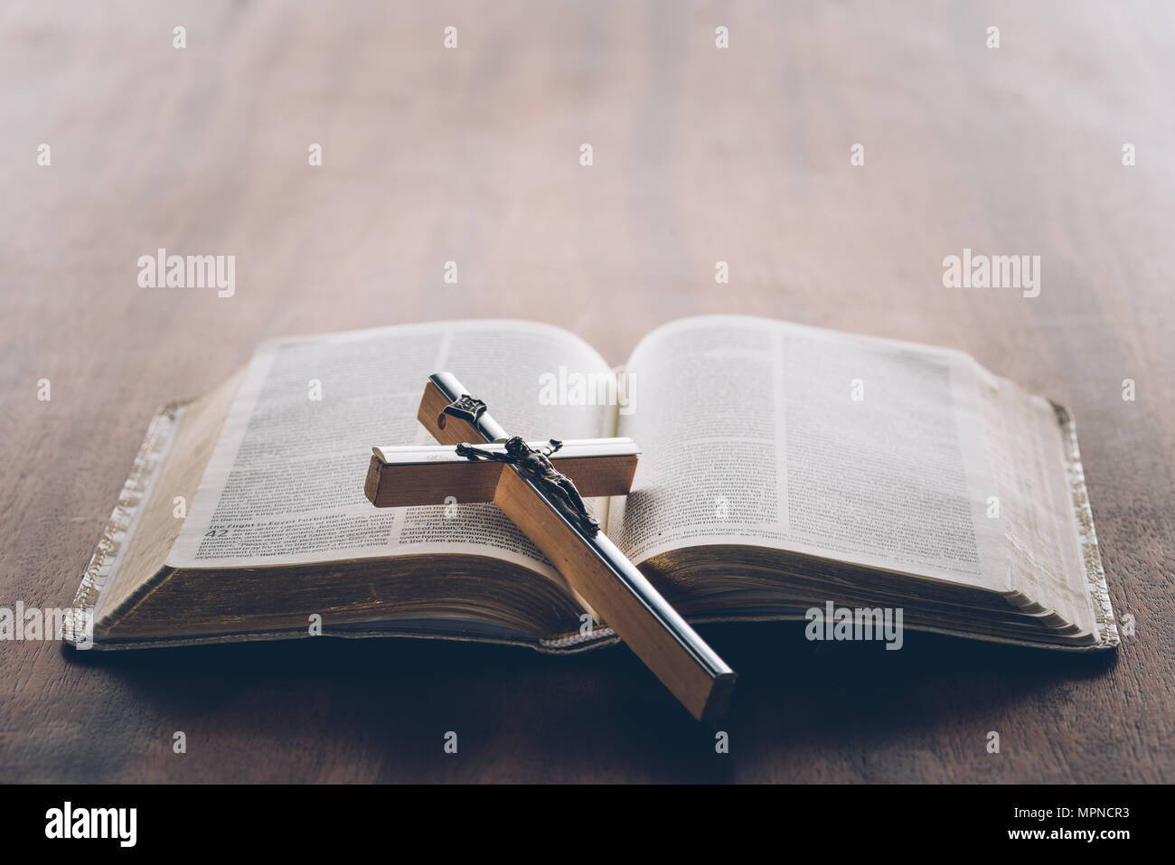 Una croce cristiana su aprire la Bibbia Foto Stock