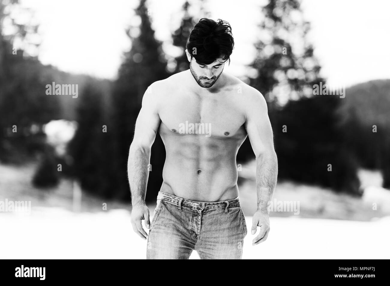 Bel giovane modello forte permanente all'aperto e flettendo i muscoli - Atletico muscolare culturista uomo in posa - un posto per il vostro testo Foto Stock
