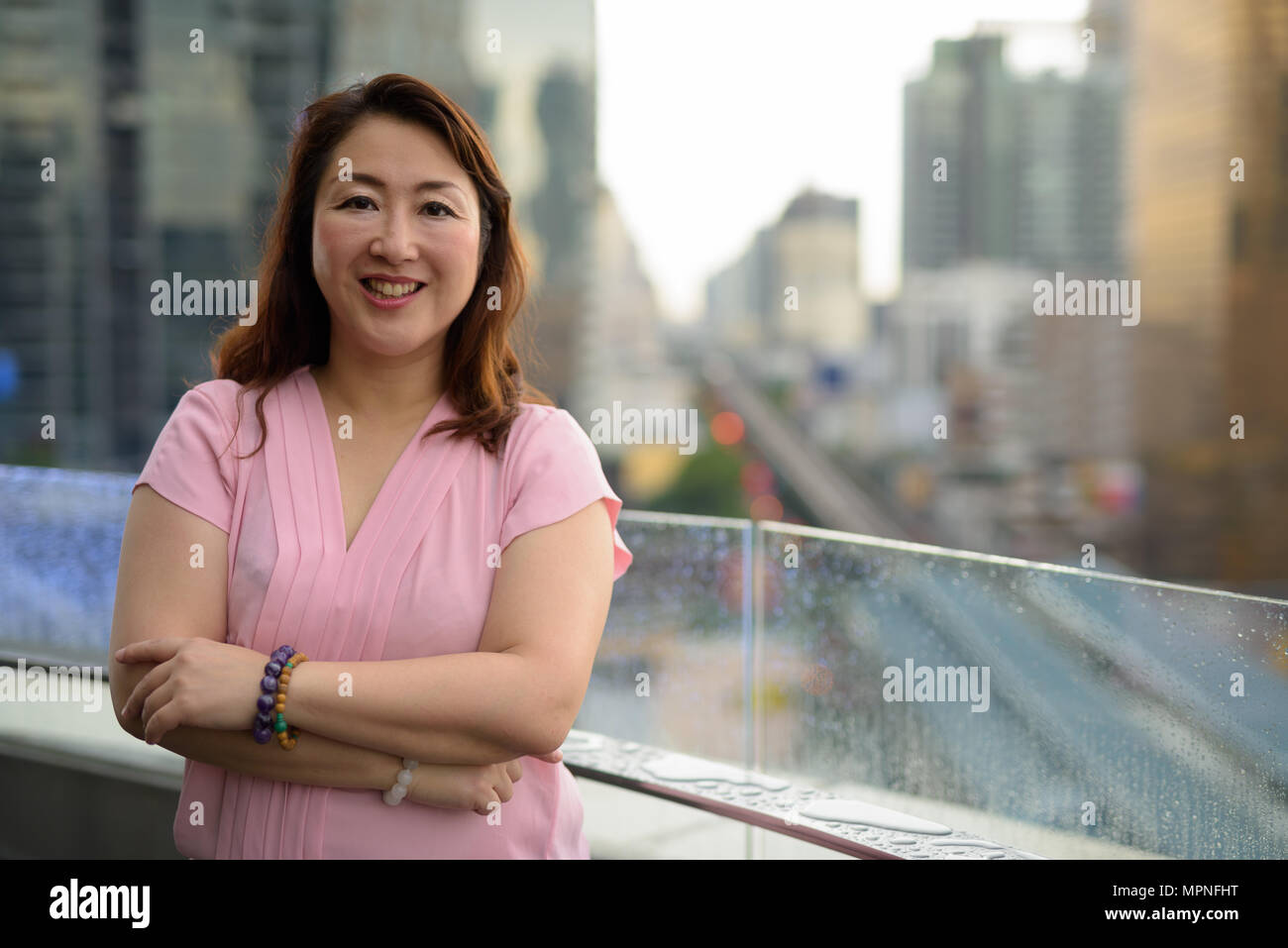 Coppia donna asiatica contro la vista della città Foto Stock