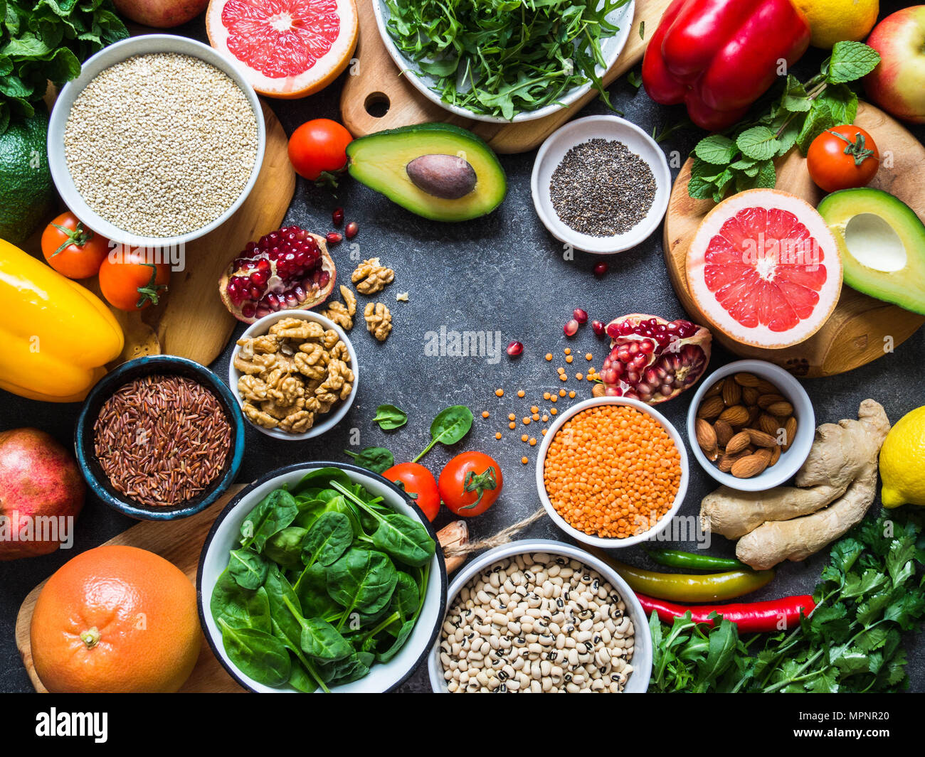 Freschi ingredienti grezzi per cucina salutare. Ortaggi e legumi, frutta, semi, cereali, fagioli, spezie, superfoods, erbe aromatiche. Pulire il cibo. Vista dall'alto. Foto Stock