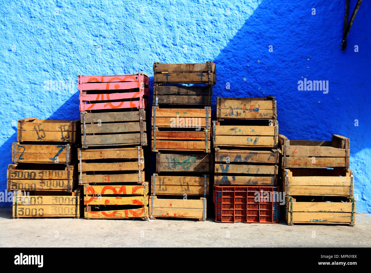 Vecchie scatole di legno per frutta e verdura impilati in una strada a Chefchaouen, Marocco Foto Stock