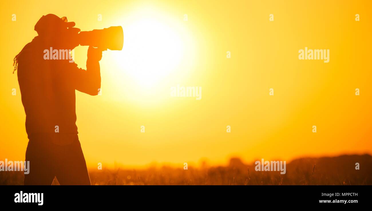 Fotografo di natura a scattare foto al tramonto. Foto panoramica. Foto Stock