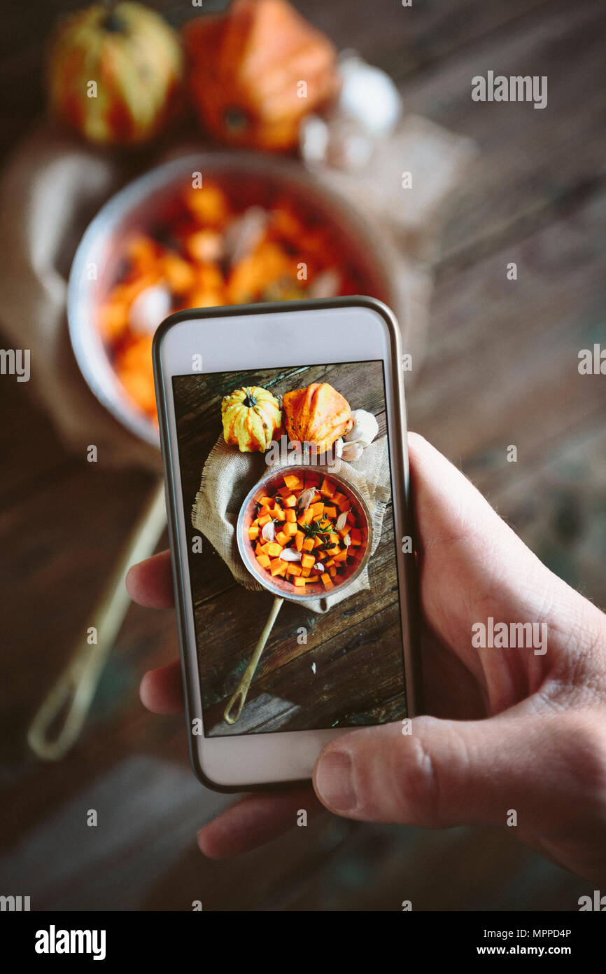 Prendendo foto di casserolle del piatto di zucca con lo smartphone Foto Stock