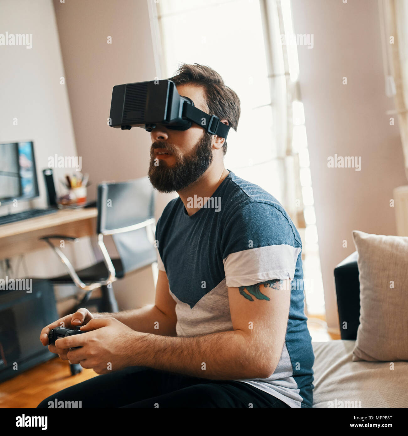 Uomo che indossa occhiali per realtà virtuale a casa la riproduzione di  giochi per computer Foto stock - Alamy