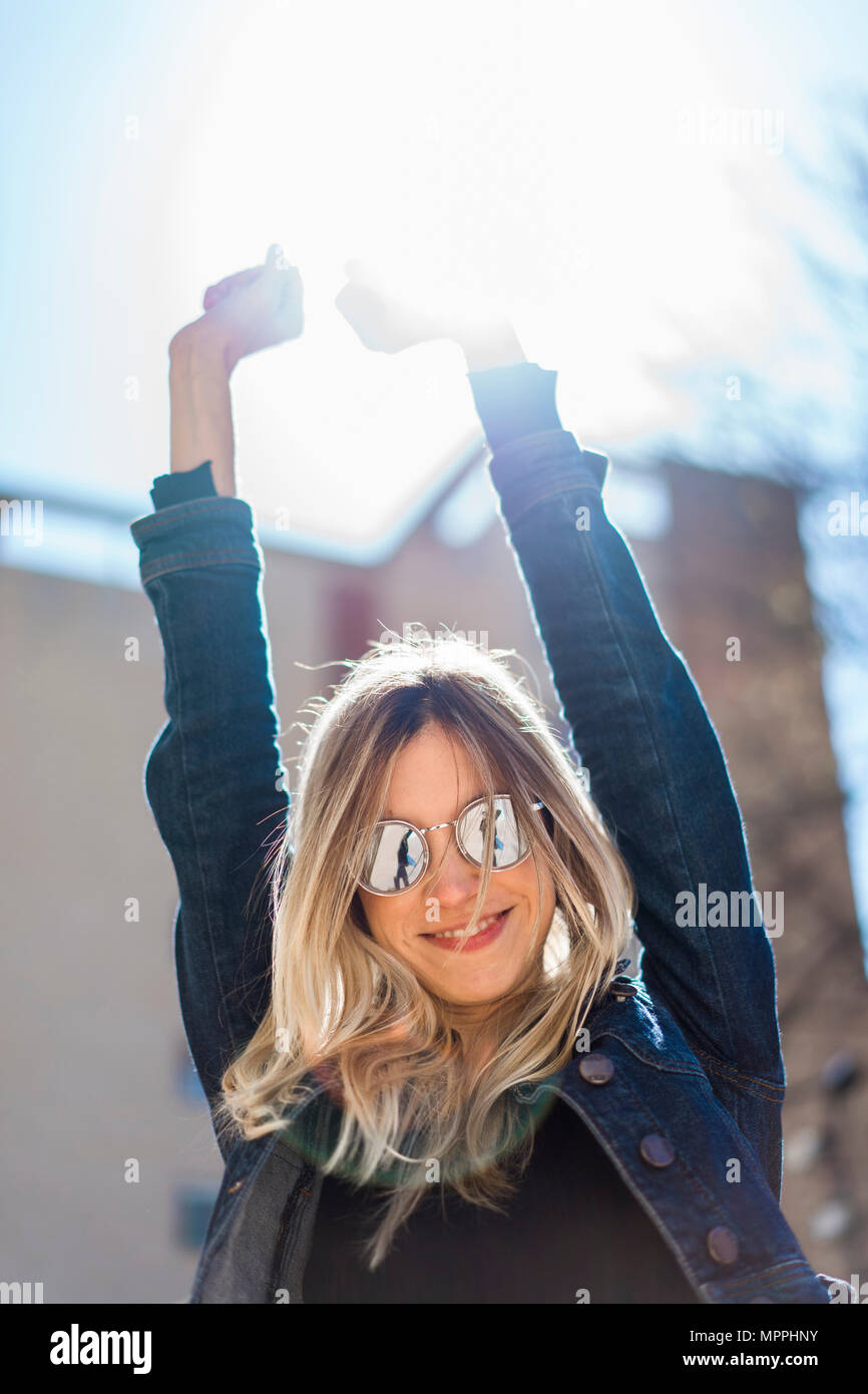 Ritratto di felice giovane donna che indossa gli occhiali da sole con mirroring Foto Stock