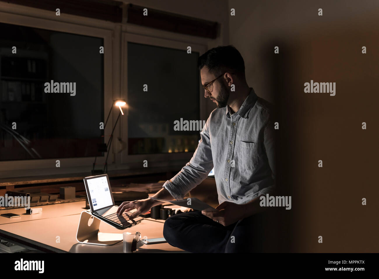 Imprenditore lavora fino a tardi in ufficio Foto Stock