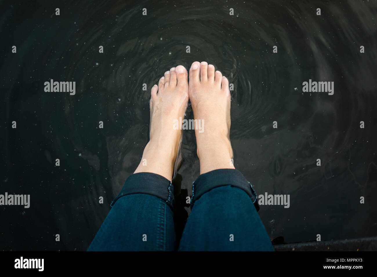 Una donna in piedi in acqua di un lago Foto Stock