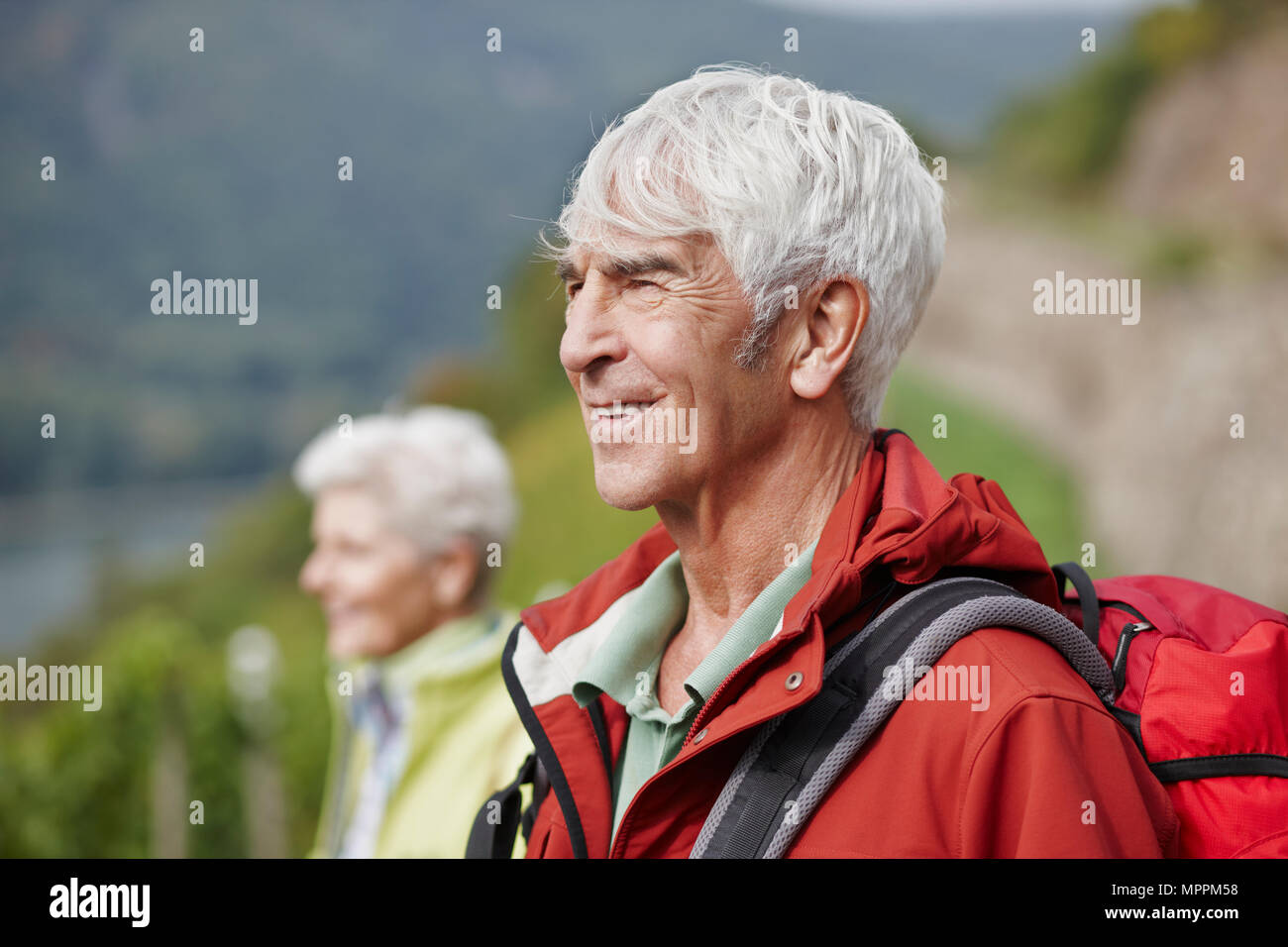 Ritratto di uomo anziano con zaino guardando a distanza Foto Stock