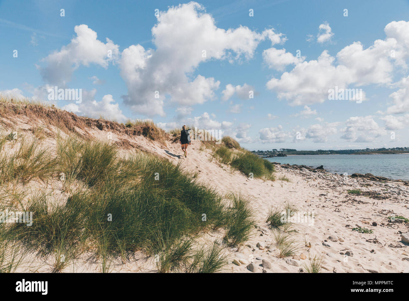 Francia, Bretagna, Landeda, Dune de Sainte-Marguerite, giovane donna camminare in dune presso la costa Foto Stock