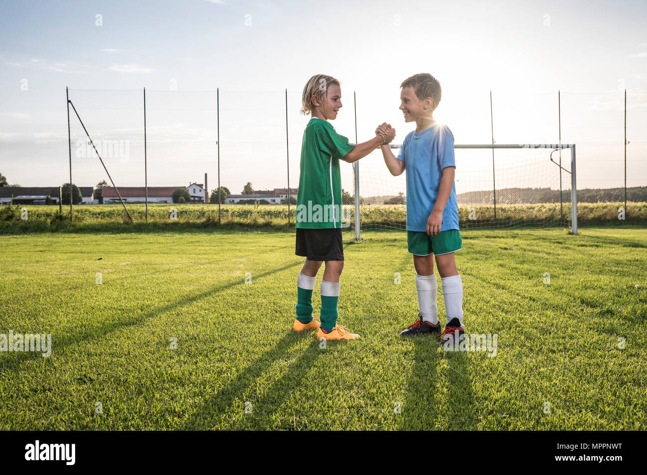 Sorridente giovani calciatori stringono le mani sul terreno di calcio Foto Stock