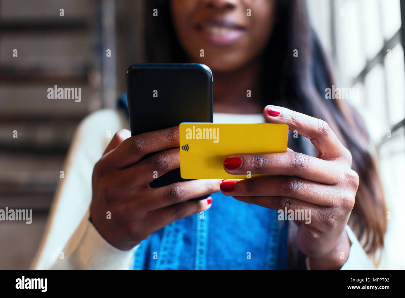 Donna di mani tenendo il telefono cellulare e il wifi e la keycard, close-up Foto Stock