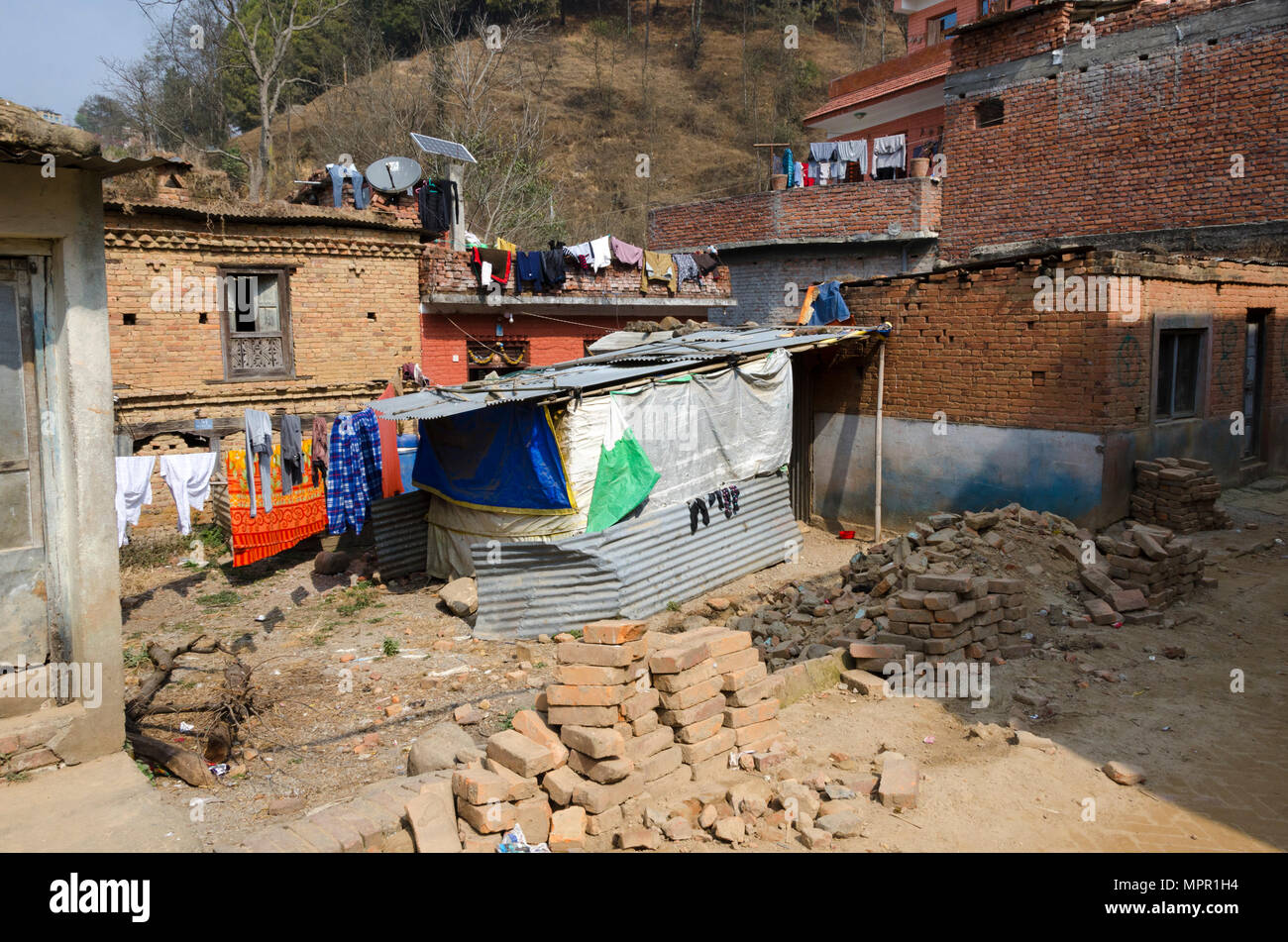 Un ricovero temporaneo sul demolito house site, dopo 2015 terremoto, Panauti, Nepal Foto Stock