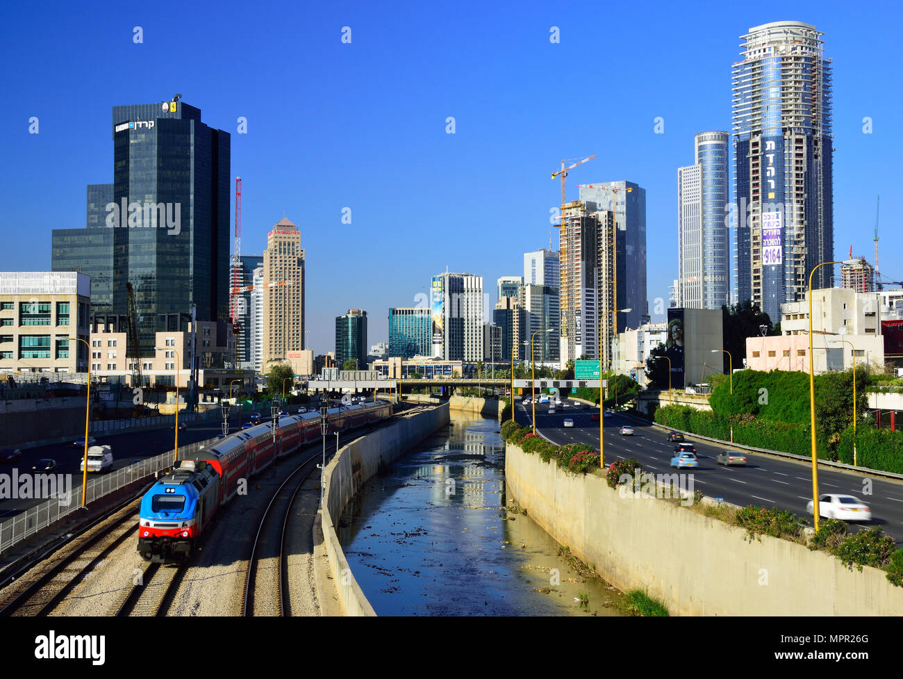 Tel Aviv cityscape. Ayalon autostrada e ferrovia centrale con il treno in avvicinamento. Foto Stock