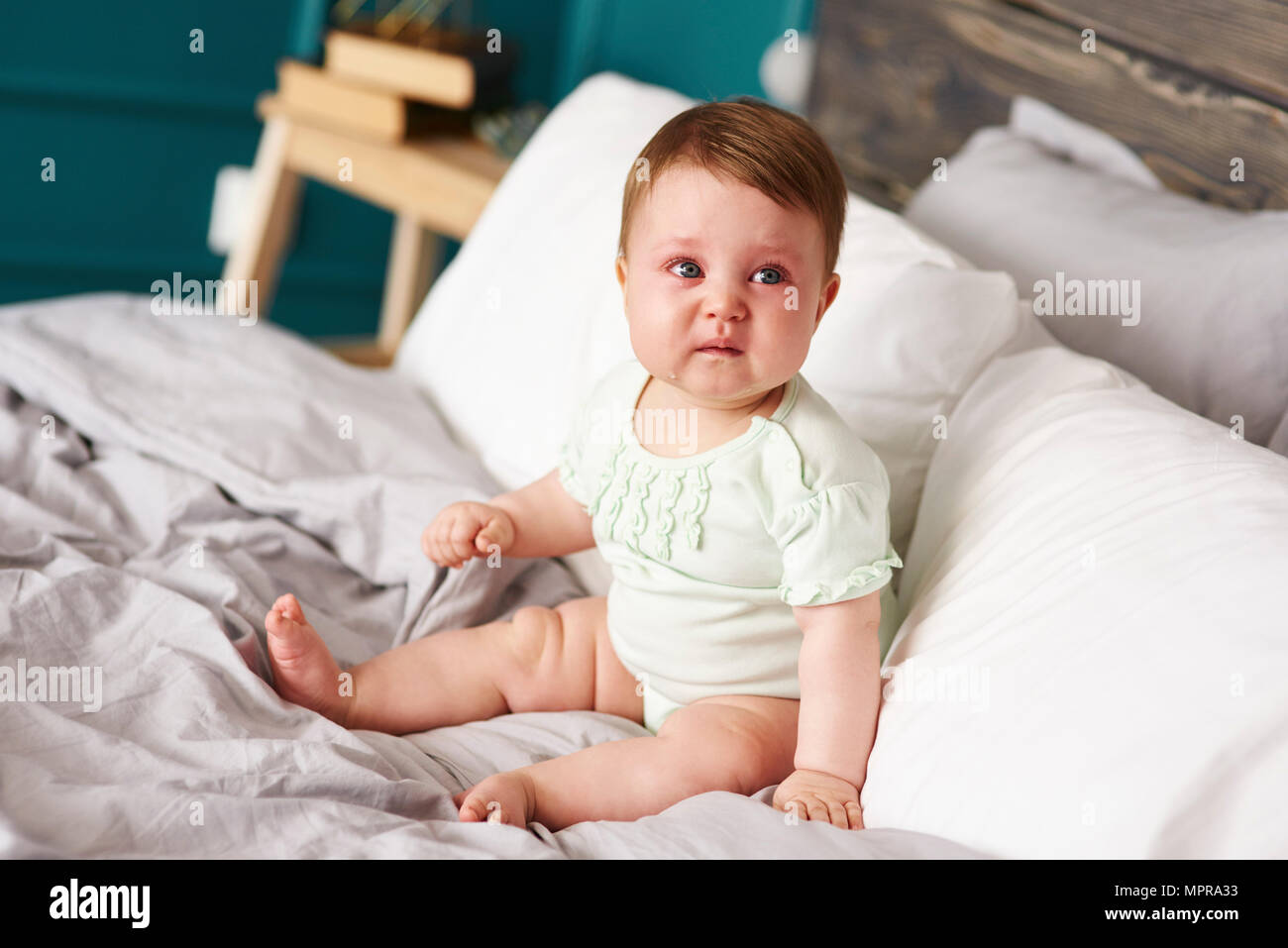 Triste pianto del bambino sul letto di casa Foto Stock