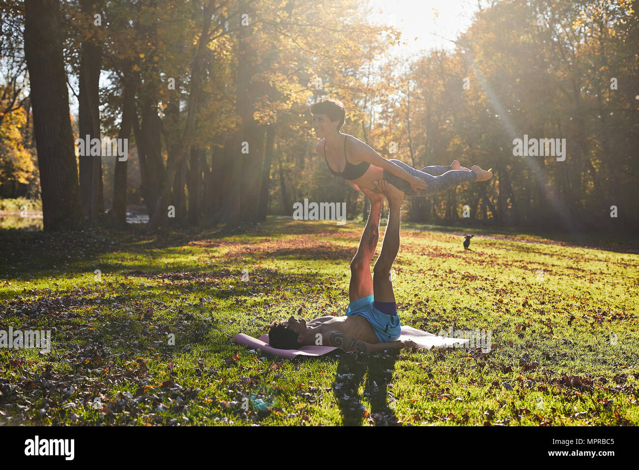 Giovane yoga a forest glade, luce solare Foto Stock