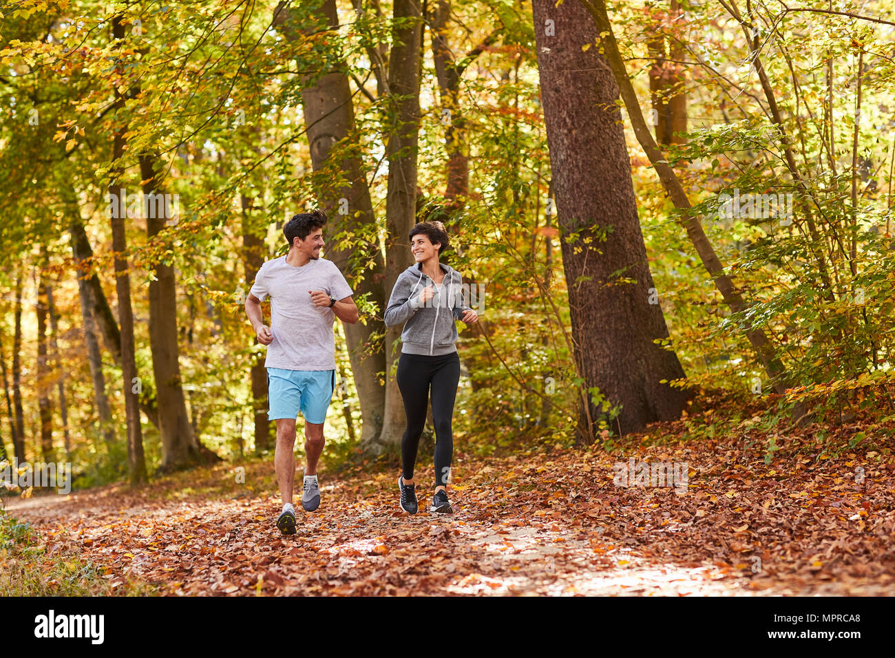 Paio di jogging sul autumnally pista forestale Foto Stock