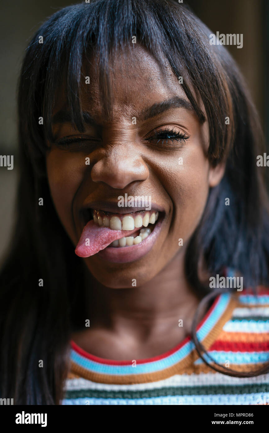 Ritratto di ridere giovane donna spuntavano lingua Foto Stock