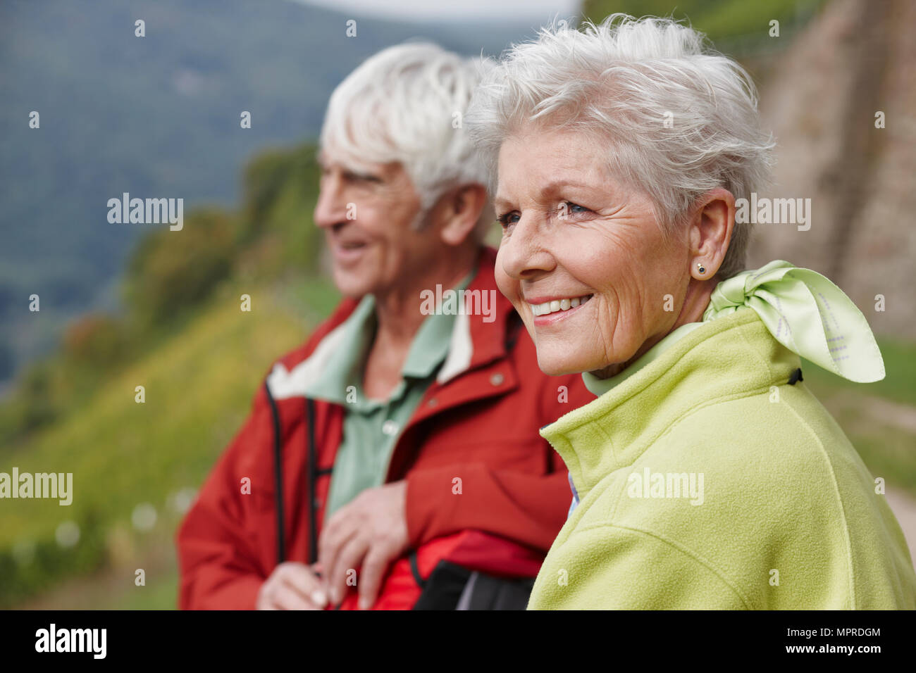Ritratto di felice donna senior con partner in background thew Foto Stock