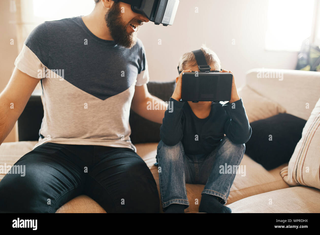 Padre e figlio di indossare occhiali per realtà virtuale a casa Foto Stock