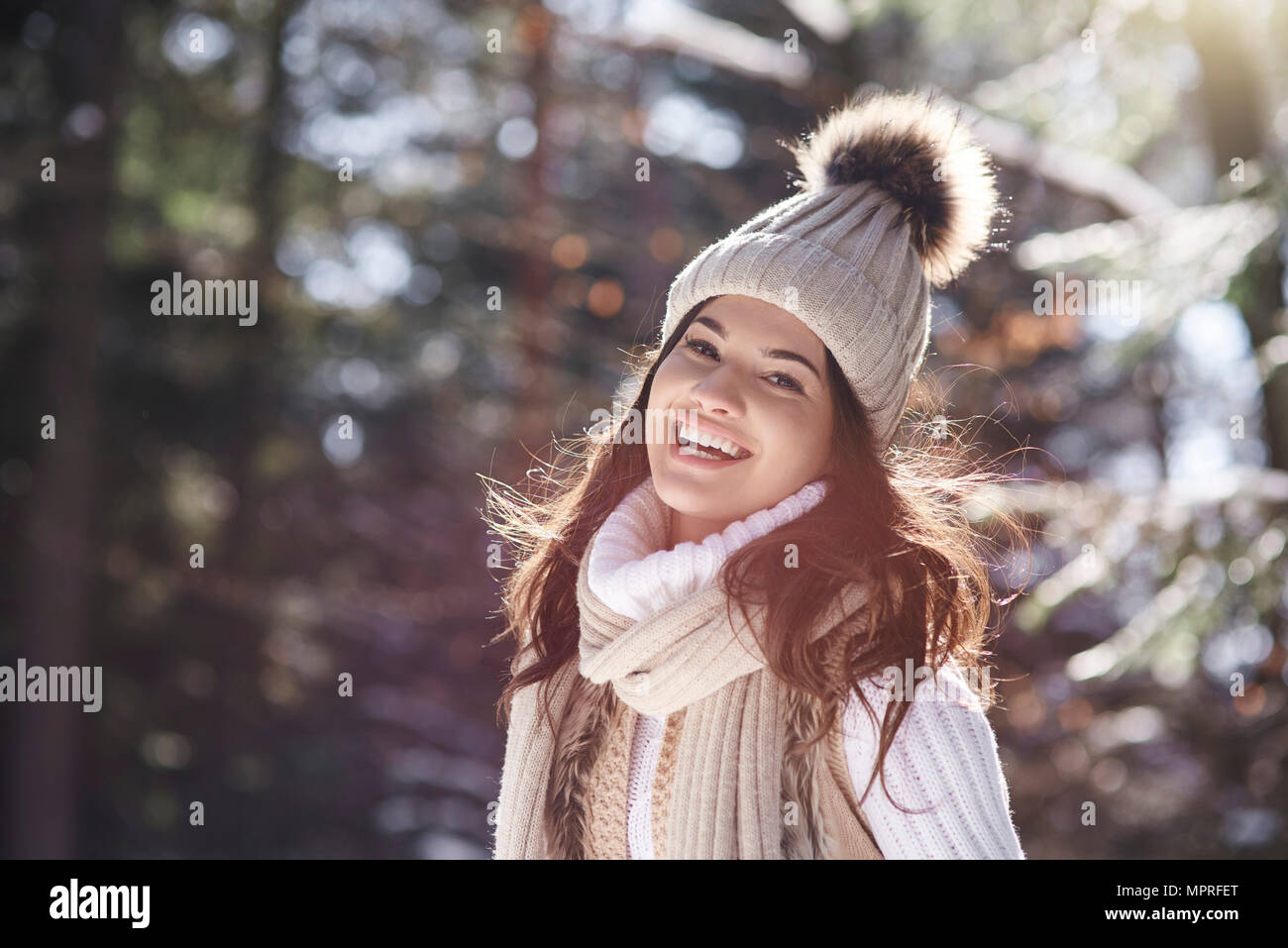 Ritratto di ridere giovane donna che indossa la maglieria nella foresta di inverno Foto Stock