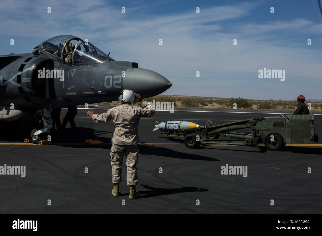 Stati Uniti Marine Corps Staff Sgt. Ranulfo Aguirre, aeromobili ordinanza tecnico con attacco Marino Squadron (VMA) 542 guide un AV-8B Harrier assegnato al Marine armi di aviazione e le tattiche di uno squadrone (MAWTS-1) durante un armamento di avanzamento e punto di rifornimento esercizio mentre il supporto di armi e tattiche istruttore (2-17) Corso 2-7 Yuma Proving Grounds, Ariz., Aprile 11, 2017. WTI è di sette settimane di formazione evento ospitato da Marine Aviation di armi e tattiche di uno squadrone (MAWTS-1) cadre, in cui si sottolinea che un'integrazione operativa delle sei funzioni del Marine Corps aviation a sostegno di un'aria marina Foto Stock