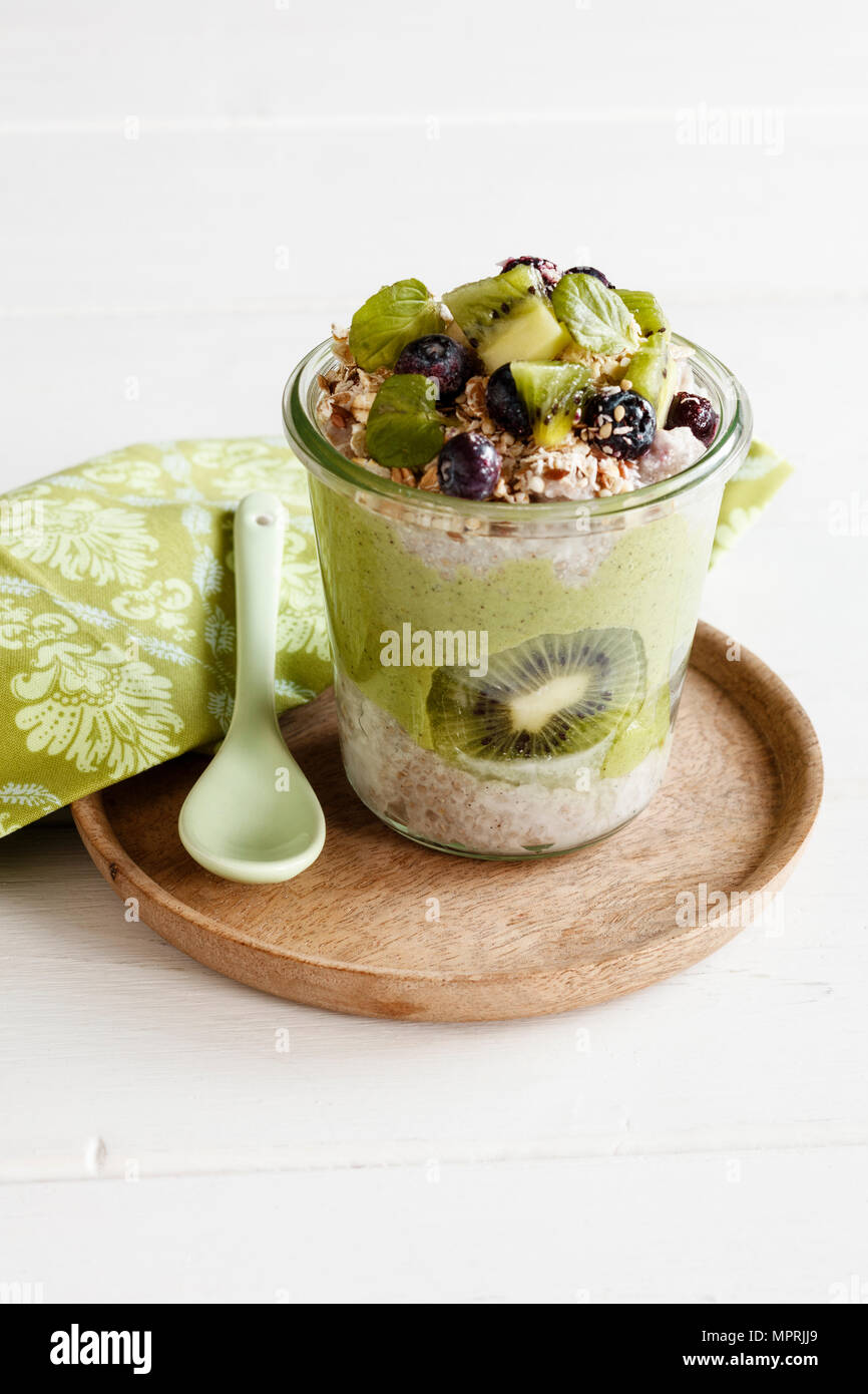 Bicchiere di Chia Pudding con kiwi, bacche, granola e Kale Smoothie Foto Stock