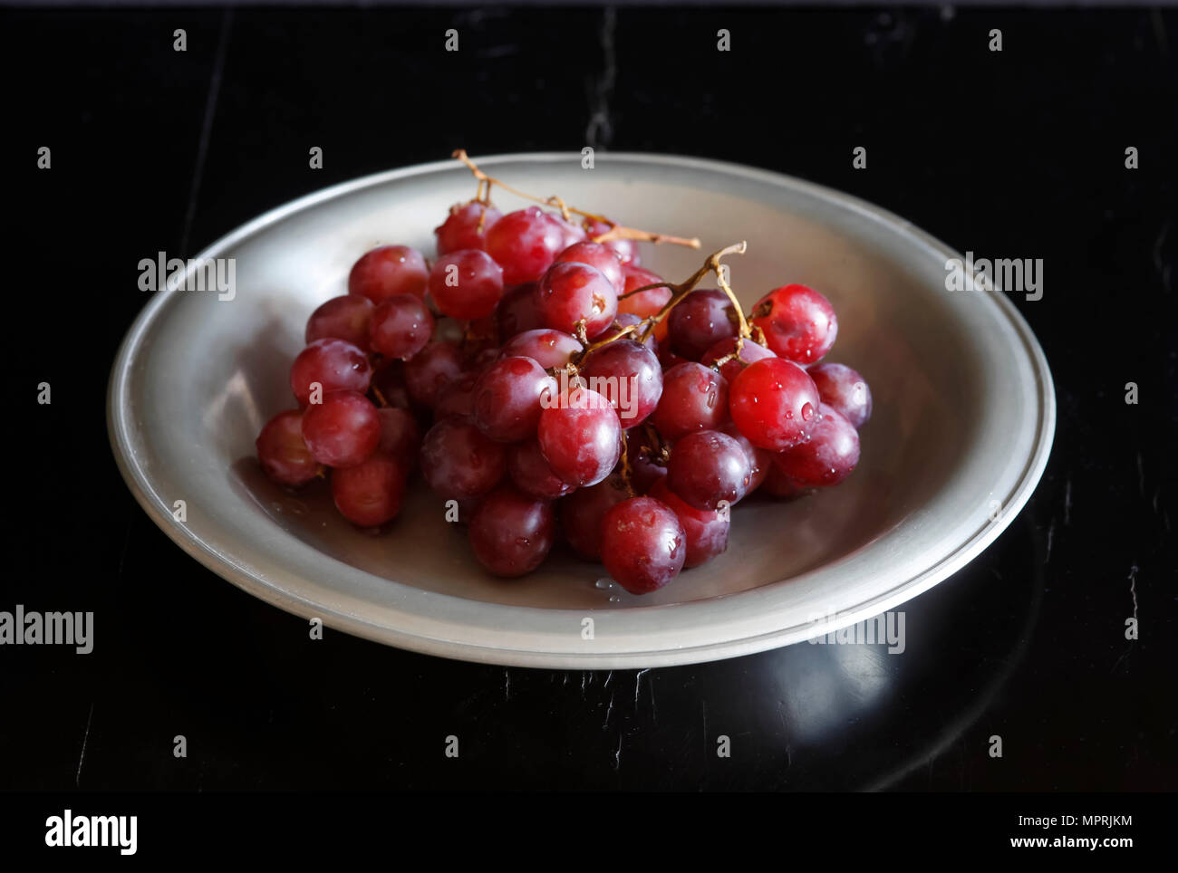 Wet uve rosse sulla piastra Foto Stock