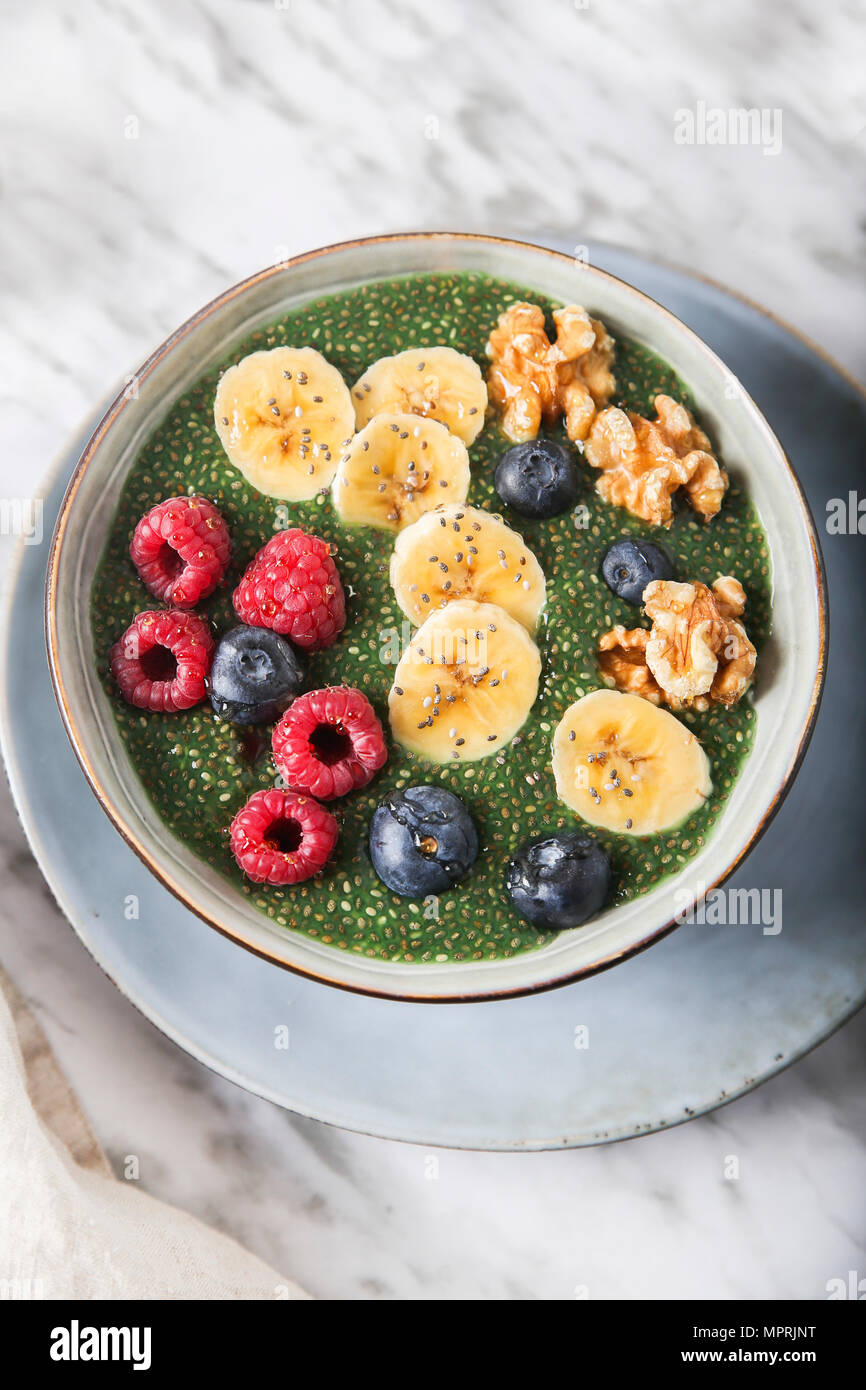 Ciotola di Buddha di verde budino di Chia con fettine di banana, mirtilli e lamponi e noci Foto Stock