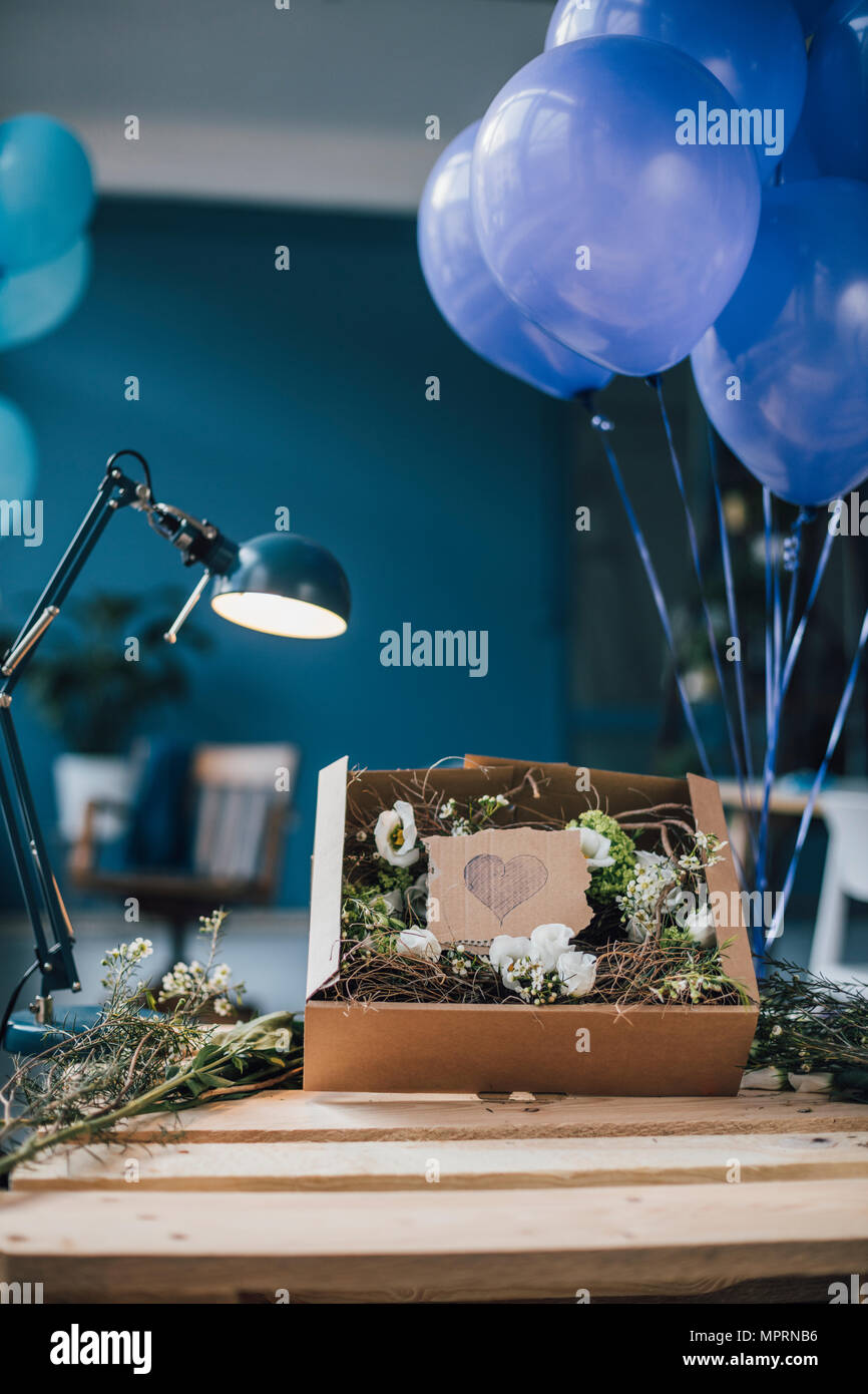 Composizione floreale in una casella sul tavolo Foto Stock