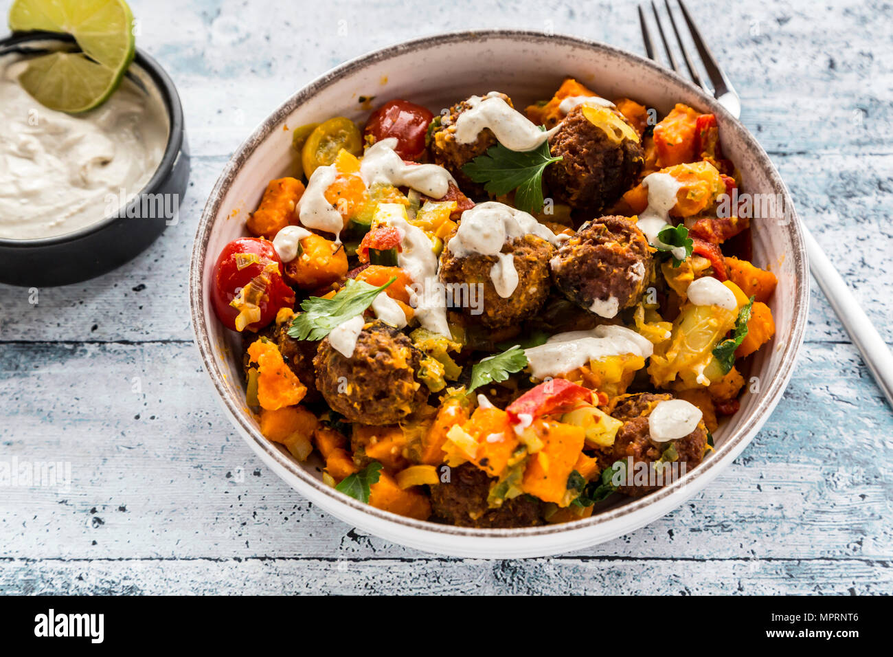 Ciotola vegetariano con dolce di patata e di pomodoro e i falafel, yogurt dip e prezzemolo Foto Stock