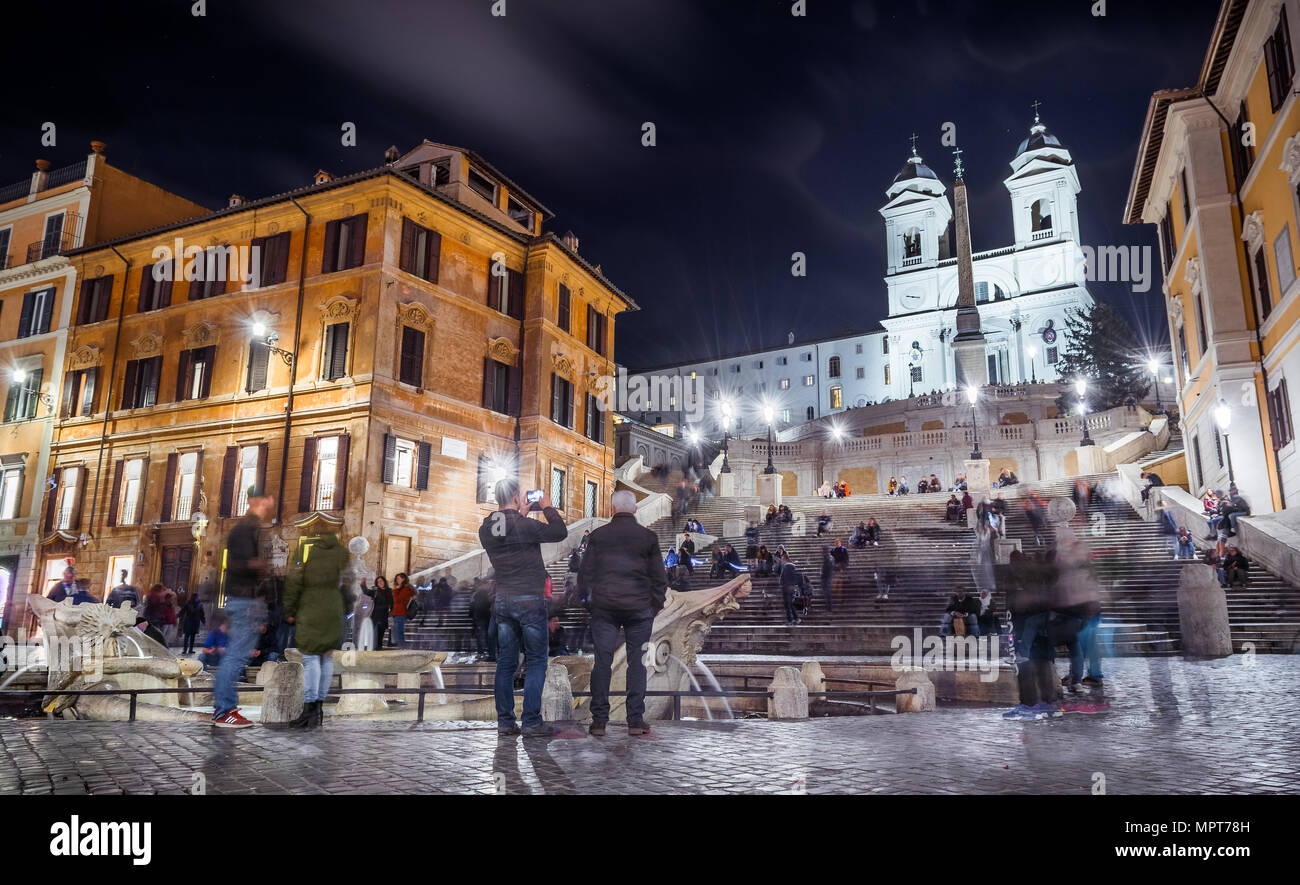 Una grande folla di turisti in visita a Piazza di Spagna e la scalinata di Trinità dei Monti scalinata e la fontana della Barcaccia a Roma Foto Stock