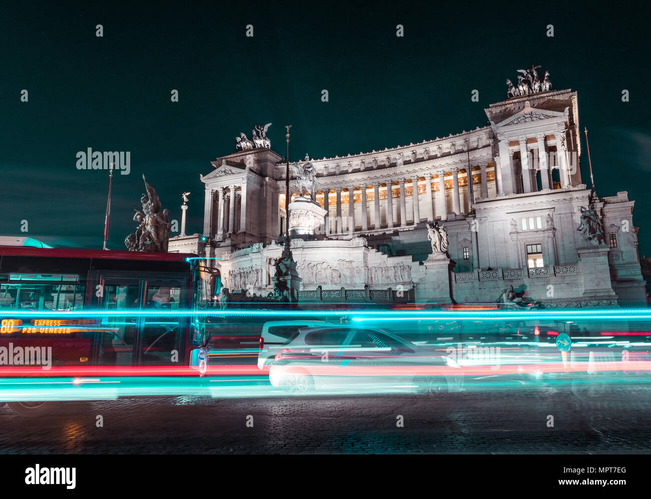 Il traffico urbano di notte di fronte all'Altare della Patria in piazza Venezia a Roma con il bus e auto Foto Stock