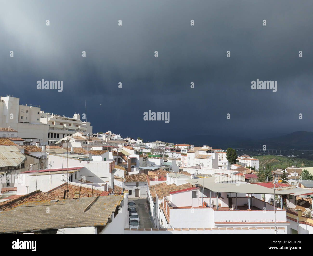 Dark nuvole di pioggia il villaggio di avvicinamento di Alora in Andalusia, Spagna Foto Stock