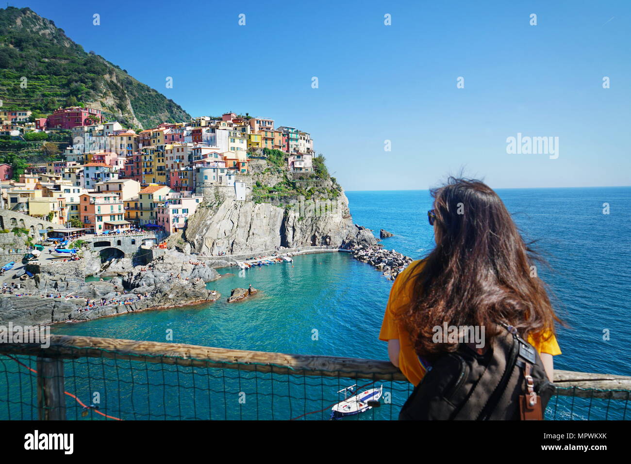 Una sola donna ammirare la splendida vista della città di Manarola. È uno dei cinque famosi villaggi colorati del Parco Nazionale delle Cinque Terre in Italia. Manarola, Foto Stock