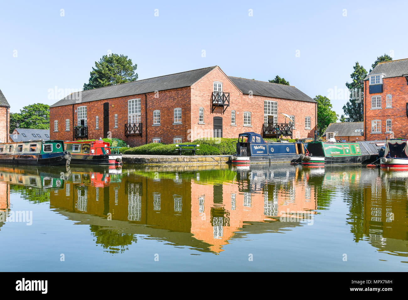 Narrowboats Ormeggiata al pontile terminale su una soleggiata giornata di primavera al Market Harborough braccio del Grand Union Canal, Inghilterra. Foto Stock