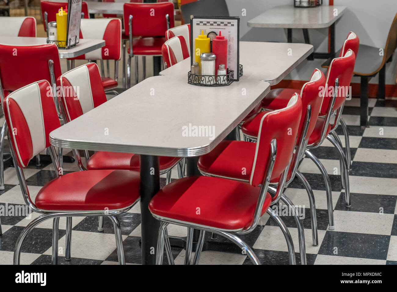 50s style diner con piastrelle bianche e nere e il pavimento rosso sedie di vinile e il laminato e tabelle di cromo Foto Stock
