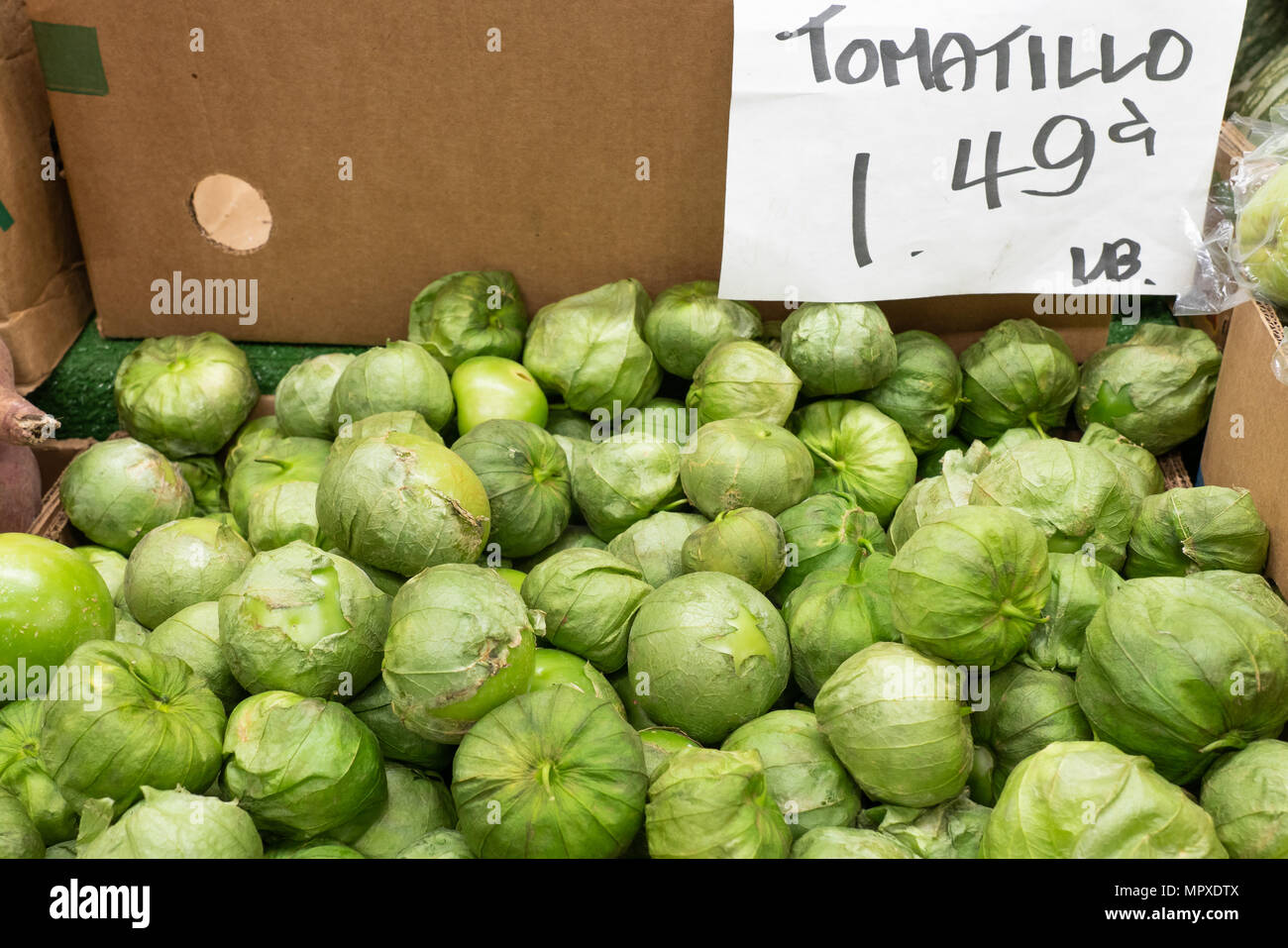 Pila di Tomatillos verdi per la vendita al mercato con segno dicendo 1,49 lb Foto Stock