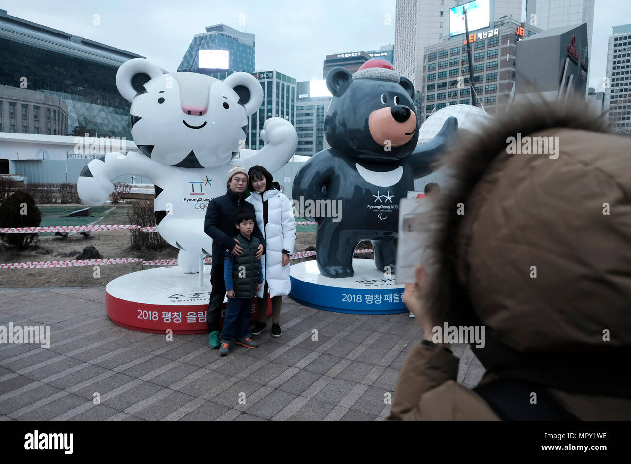 Persone che pongono nella città di Seul accanto a la mascotte ufficiale per Pyeongchang 2018 Olimpiadi invernali che si svolgerà nella contea di Pyeongchang, Corea del Sud Foto Stock