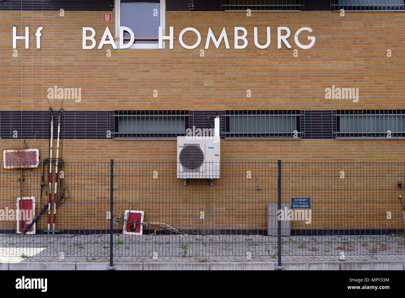 Il clinker facciata della stazione ferroviaria di Bad Homburg nel cortile con ventole e recinzione. Foto Stock