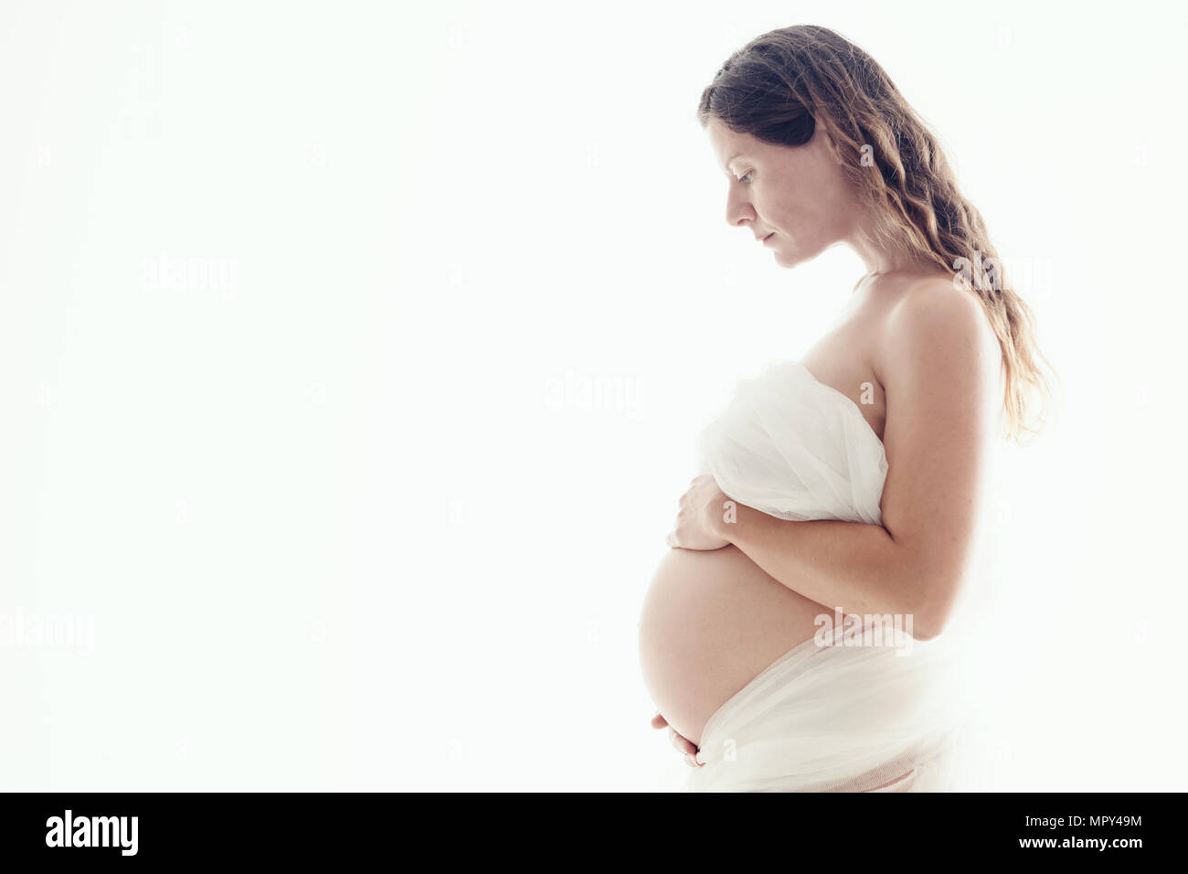 Lato ritratto di donna incinta su sfondo bianco,Istanbul Foto Stock