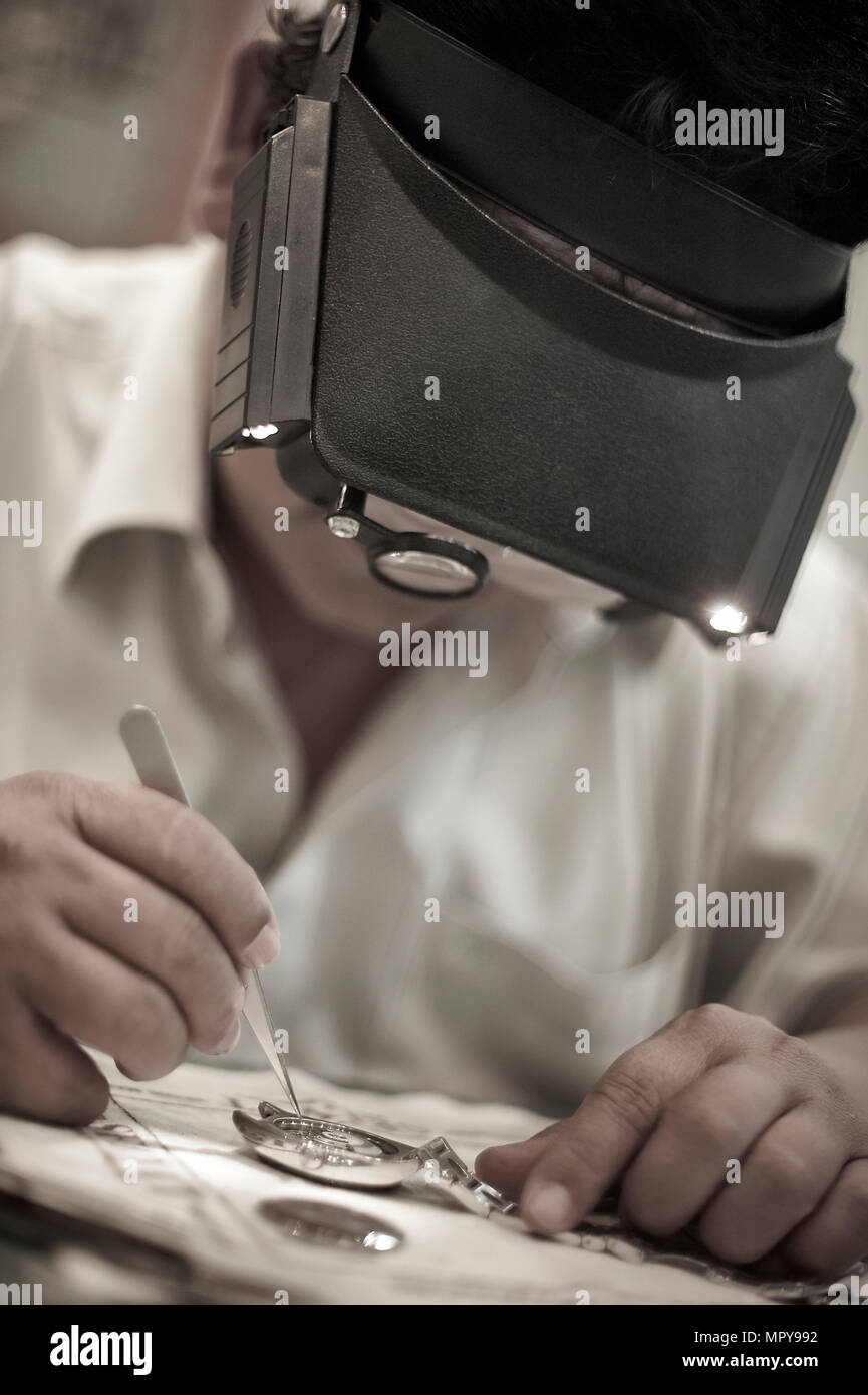 Uomo che ripara guarda sulla tabella in officina Foto Stock