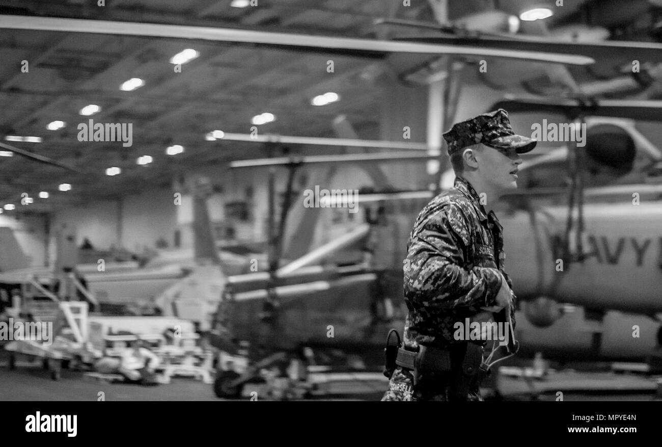 170420-N-AF077-023 GOLFO ARABICO (20 aprile 2017) Master-at-Arms di terza classe Avery Scarsella esegue una scansione di sicurezza dell'hangar bay durante un tiratore attivo e mass casualty praticare a bordo della portaerei USS George H.W. Bussola (CVN 77) (GHWB). Il George H.W. Bush Carrier Strike gruppo è distribuito negli Stati Uniti Quinta Flotta area di operazioni a sostegno della sicurezza marittima operazioni destinate a rassicurare gli alleati e partner e preservare la libertà di navigazione un libero flusso di commercio nella regione. (U.S. Foto di Marina di Massa lo specialista di comunicazione 1a classe Sean male/rilasciato) Foto Stock