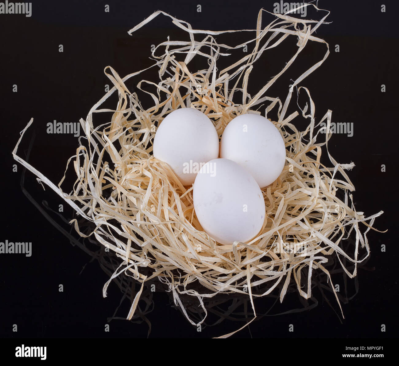 Tre uova nel nido come su uno sfondo nero Foto Stock