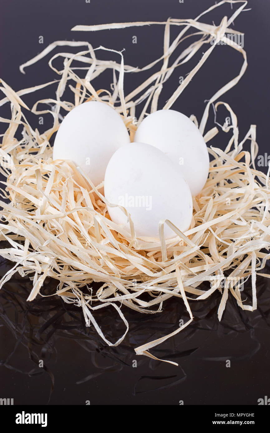Tre uova nel nido come su uno sfondo nero Foto Stock