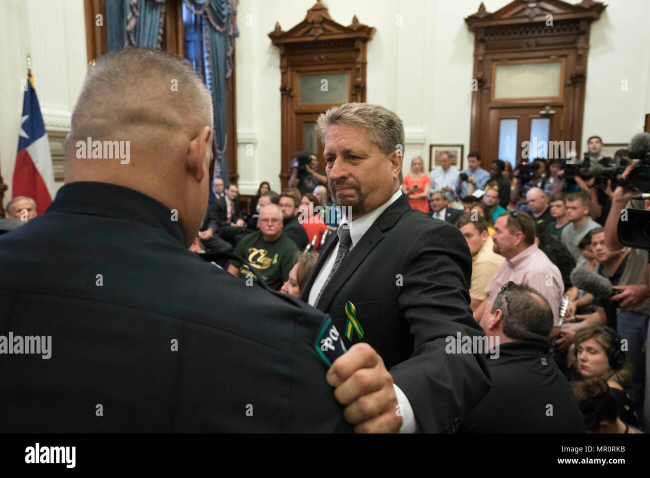 Santa Fe, TX, resident Scot riso abbracci John Barnes, una scuola poliziotto ferito da parte del tiratore che ha ucciso 10 persone a Santa Fe di alta scuola, nel corso di una audizione Capitol detenute da Gov. Greg Abbott per lo studio di sicurezza della scuola studente e le questioni relative alla salute mentale. Foto Stock