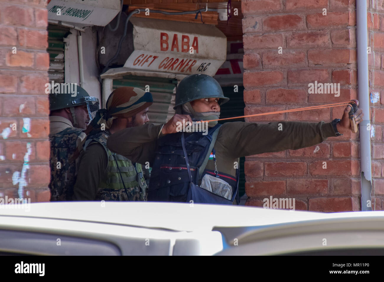 Il personale di polizia con la gomma getta pietre verso i manifestanti durante gli scontri nella città vecchia Srinagar capitale estiva del Kashmir indiano. Scontri scoppiati subito dopo la preghiera del venerdì in area del centro cittadino di Srinagar, Kashmir indiano, il venerdì. Diverse persone sono rimaste ferite dopo che le forze governative hanno sparato pistole di pellet e gas lacrimogeni gusci su persone che si sono riuniti dopo venerdì pomeriggio le preghiere che protestavano contro la regola di indiana nella regione contesa. Foto Stock