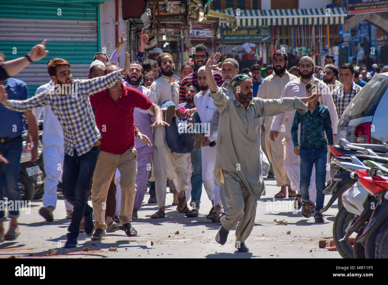 Persone che trasportano la persona ferita per il trattamento durante gli scontri tra le forze indiane e persone in Srinagar capitale estiva del Kashmir indiano. Scontri scoppiati subito dopo la preghiera del venerdì in area del centro cittadino di Srinagar, Kashmir indiano, il venerdì. Diverse persone sono rimaste ferite dopo che le forze governative hanno sparato pistole di pellet e gas lacrimogeni gusci su persone che si sono riuniti dopo venerdì pomeriggio le preghiere che protestavano contro la regola di indiana nella regione contesa. Foto Stock