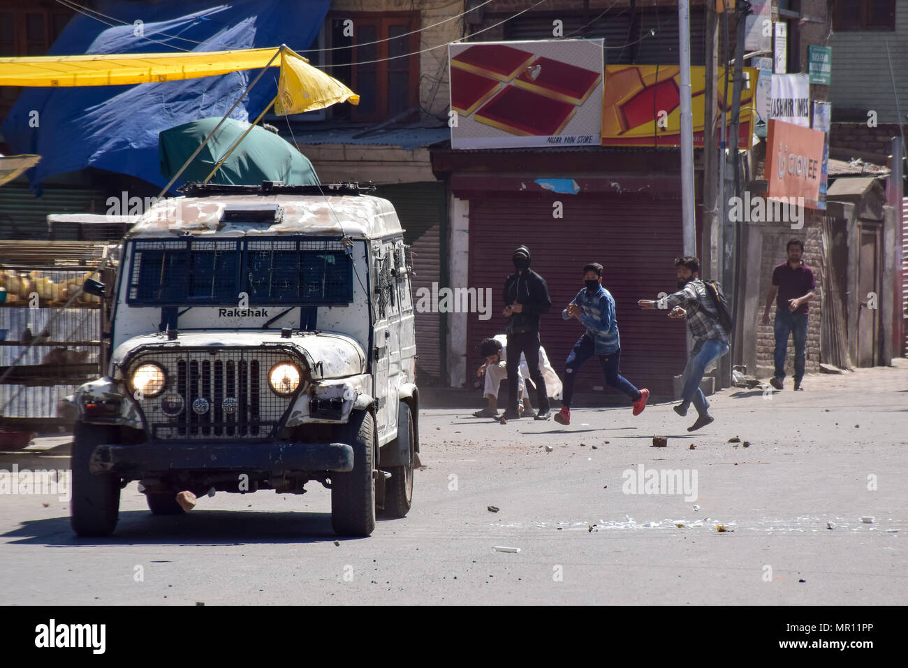I manifestanti pietre di concia su un veicolo della polizia durante scontri nella città vecchia di Srinagar capitale estiva del Kashmir indiano dopo la preghiera del venerdì. Scontri scoppiati subito dopo la preghiera del venerdì in area del centro cittadino di Srinagar, Kashmir indiano, il venerdì. Diverse persone sono rimaste ferite dopo che le forze governative hanno sparato pistole di pellet e gas lacrimogeni gusci su persone che si sono riuniti dopo venerdì pomeriggio le preghiere che protestavano contro la regola di indiana nella regione contesa. Foto Stock